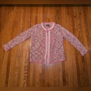 Pink tweed cardigan with pearl trim and fringe details.